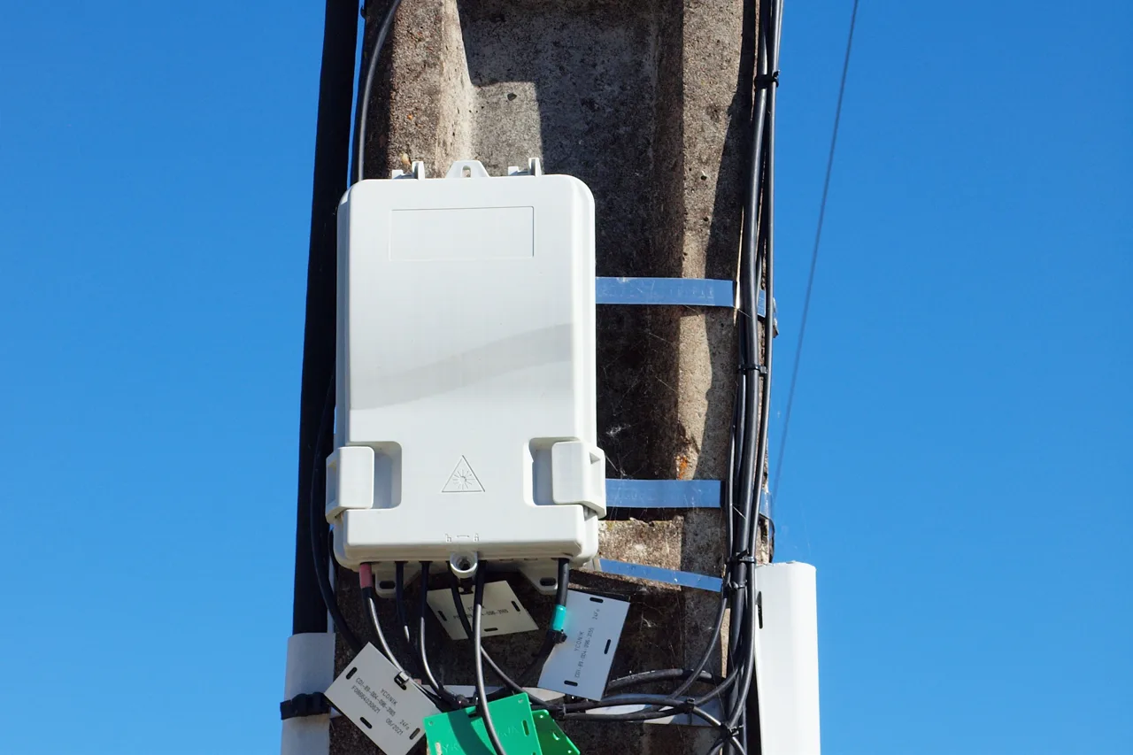 Boîtier de distribution de fibre optique installé sur un poteau, illustrant l'accès Internet par fibre proposé par Alsace Réseau Neutre