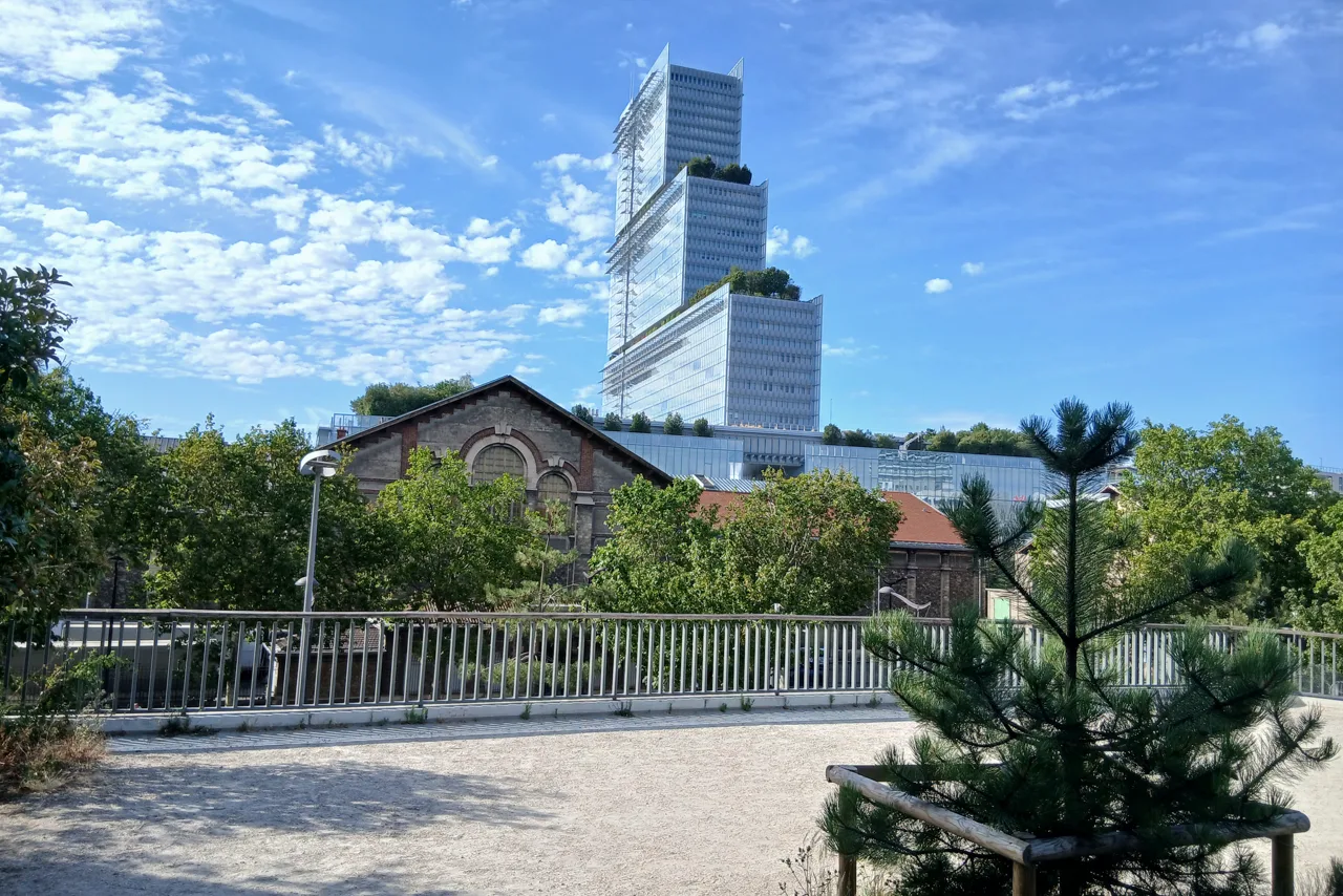 Le bâtiment du tribunal judiciaire de Paris, tour de verre étagée, vu depuis le parc Clichy-Batignolles