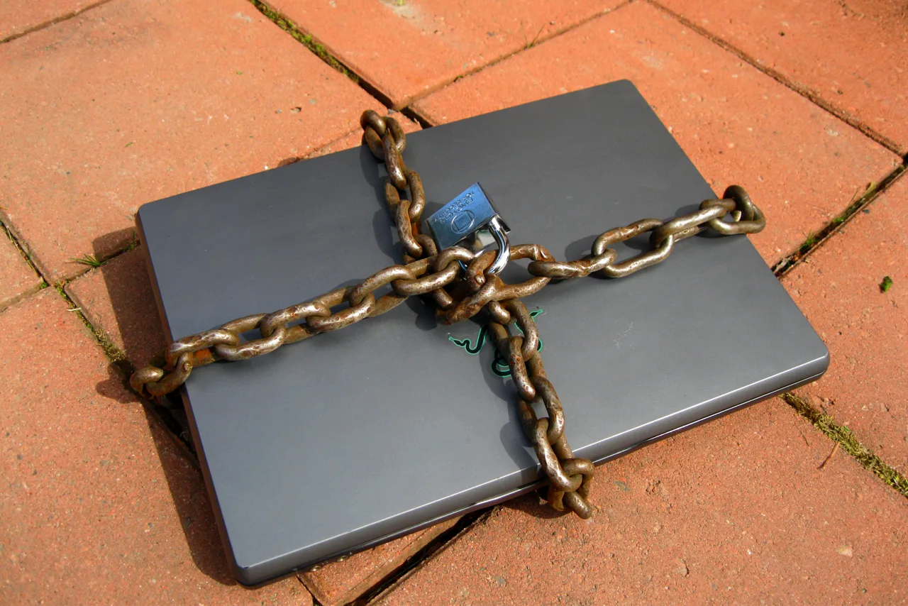 Ordinateur portable entouré d'une chaîne fermée par un cadenas